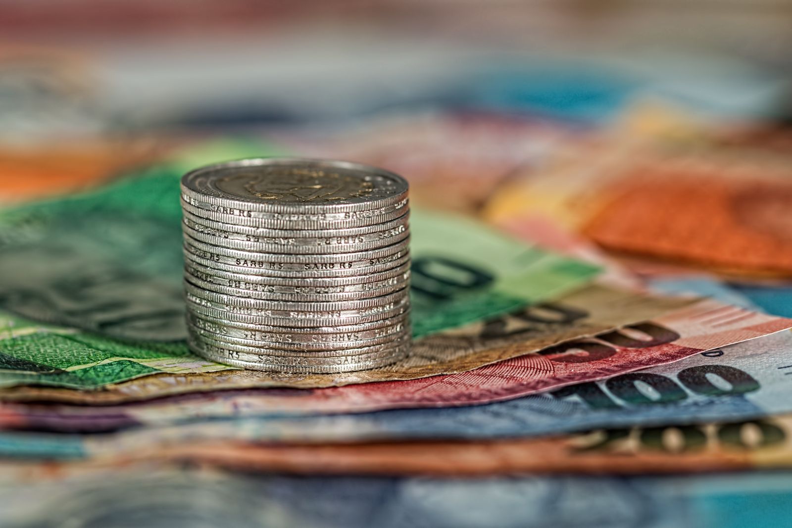 Billets du monde colorés et pile de pièces d’argent